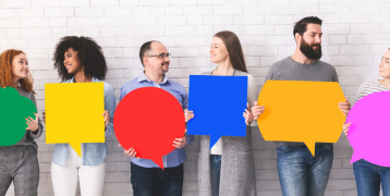 People having a friendly exchange and holding bright coloured dialog balloons